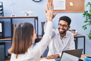man and woman high five at office